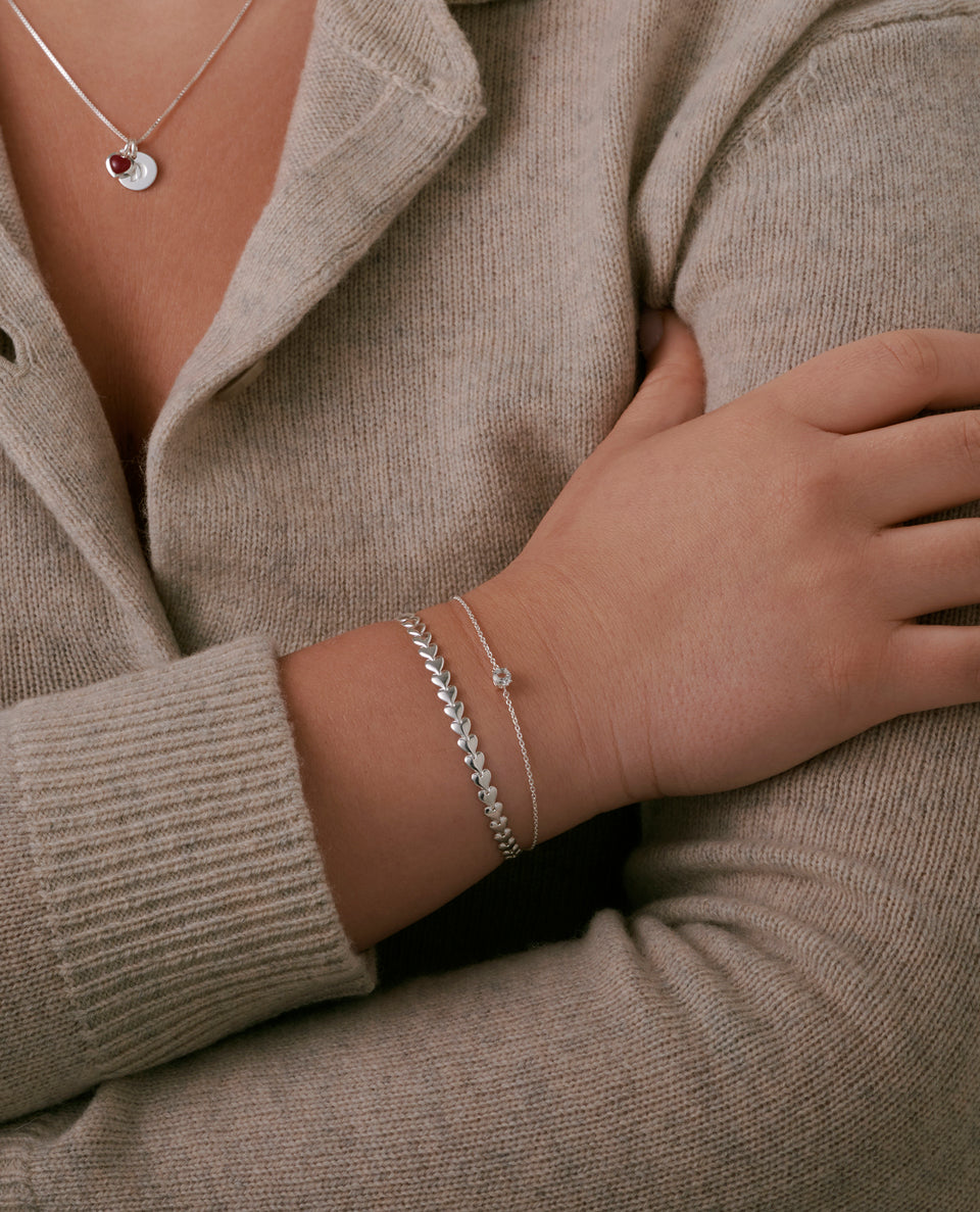A shot of a model wearing the Darling Bracelet Silver, featuring a chain of connected hearts.