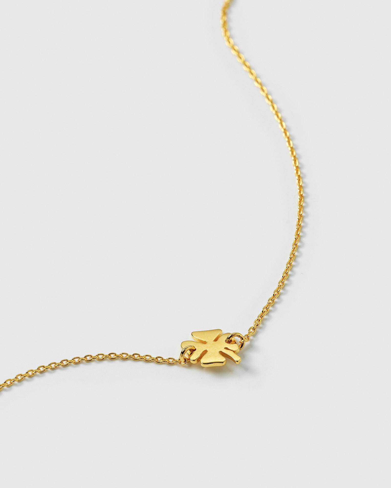 A close-up product shot of the Bring Me Luck Bracelet in gold, highlighting its delicate chain and small four-leaf clover pendant.