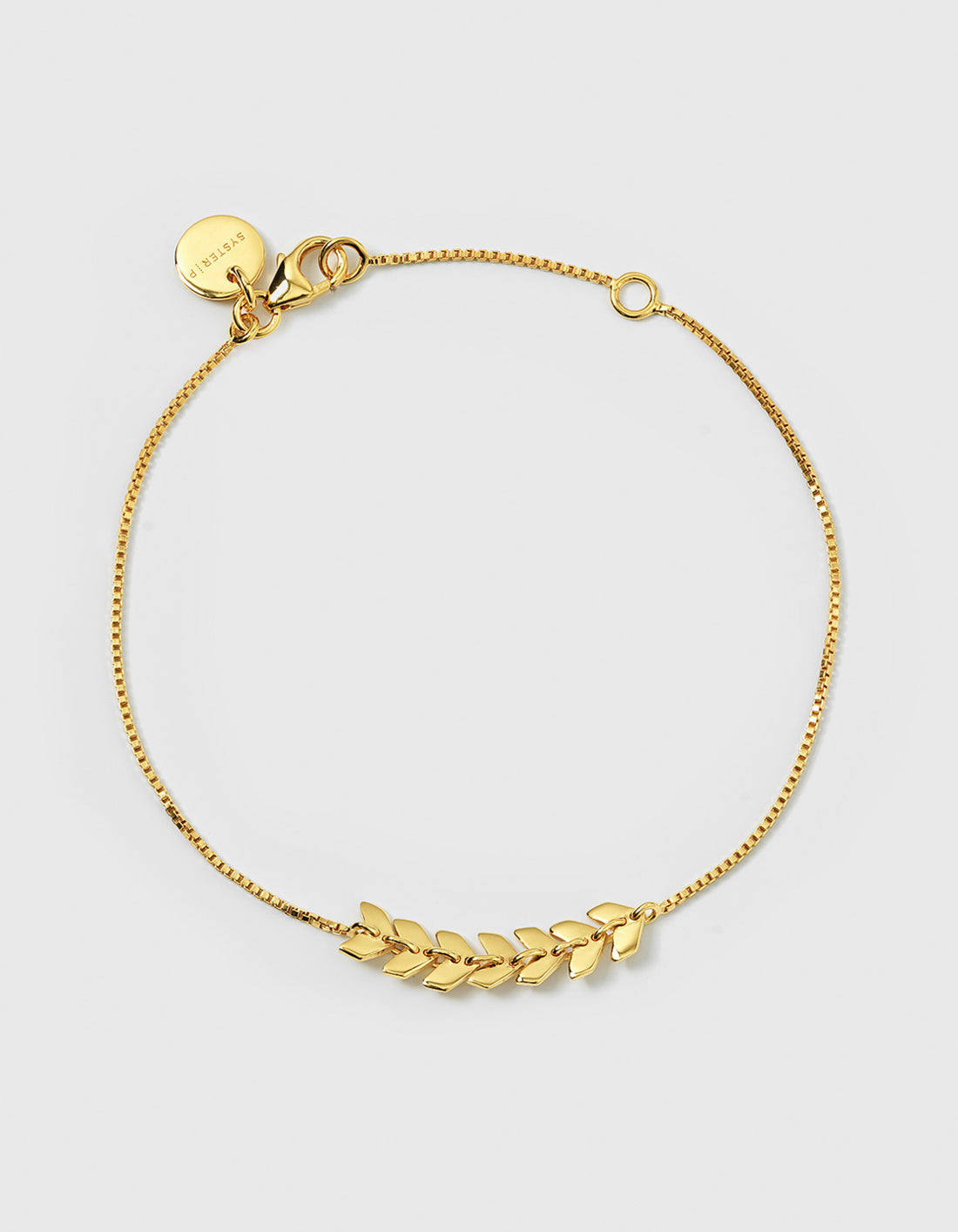 A full view of the Layers Simone Bracelet in gold, showcasing its delicate chain and a central design made of small, leaf-like links.