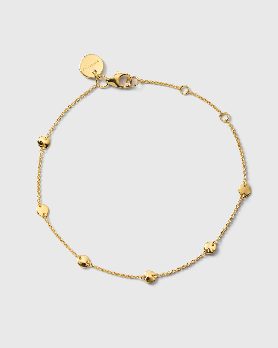 A product shot of the Solea Bracelet in gold, laid out in a circle to show its design of a delicate chain adorned with small, round hammered circles.