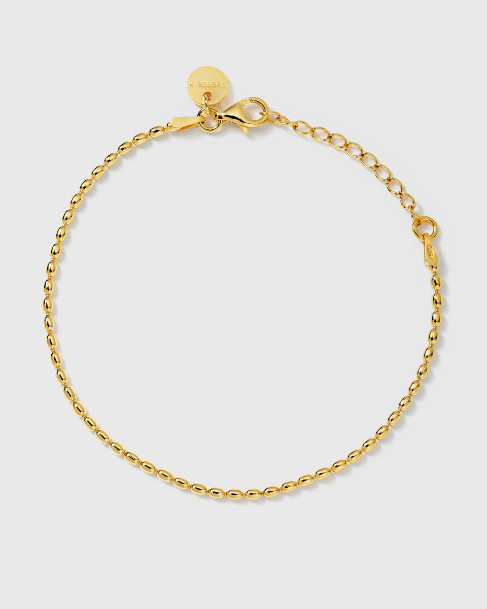 A product shot of the Lunetta Bracelet in gold, laid out in a circle to show its delicate design of small, oval-shaped beads.