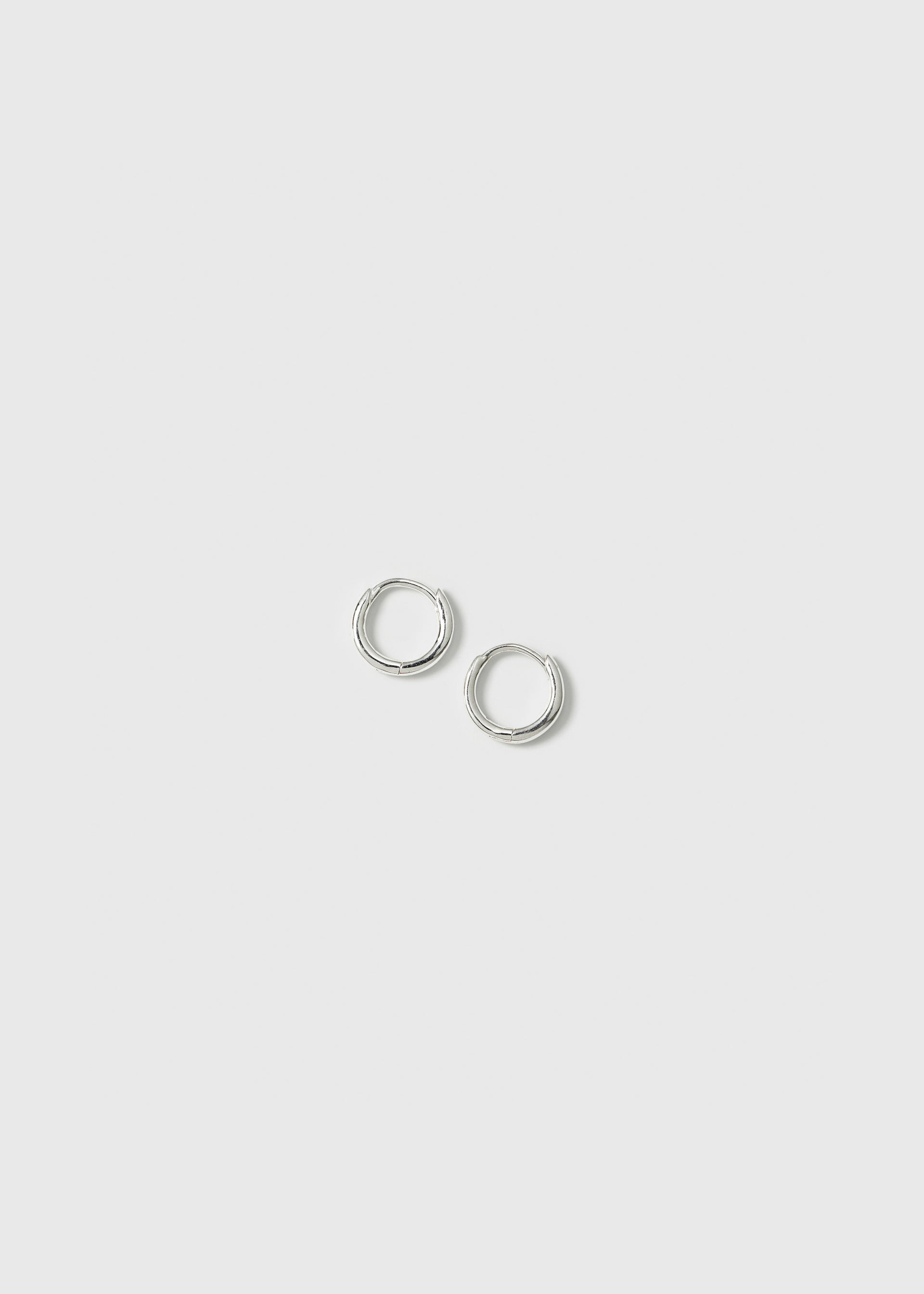 A product shot of the Beloved Mini Hoops in silver, a pair of small and classic plain hoop earrings.