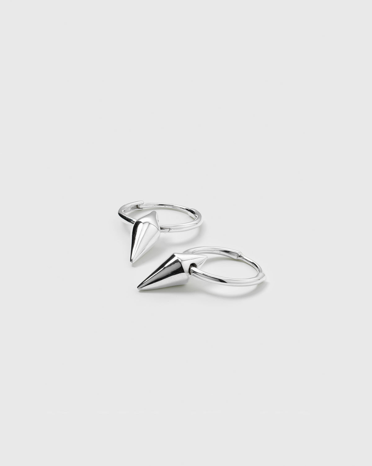 A product shot of the Harvey Small Spike Hoops in silver, showing the pair of small hoop earrings, each with a dangling cone-shaped spike charm.