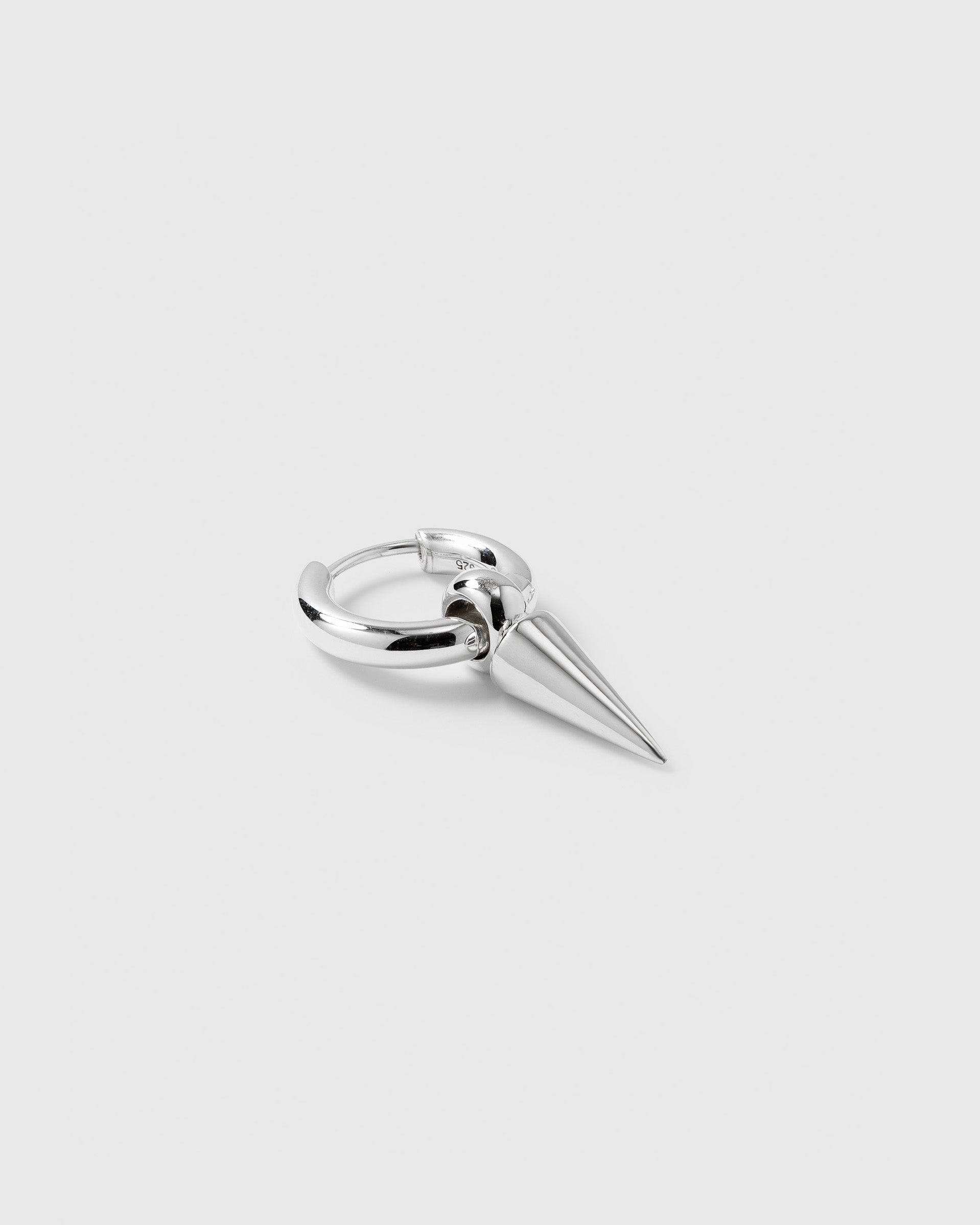 A product shot of the Juno Single Hoop in silver, featuring a small hoop with a dangling spike pendant.