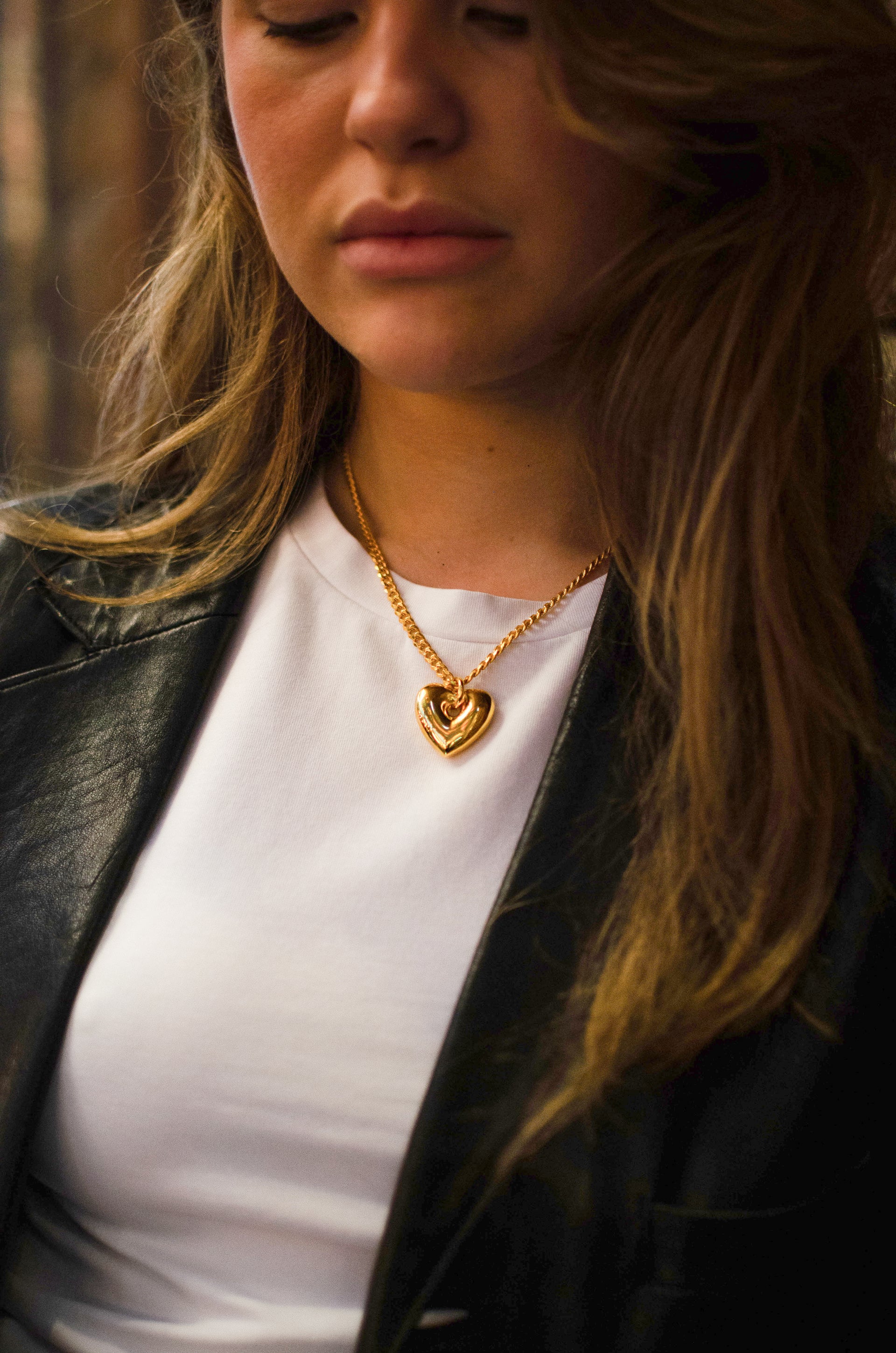 A gold necklace with a fat heart