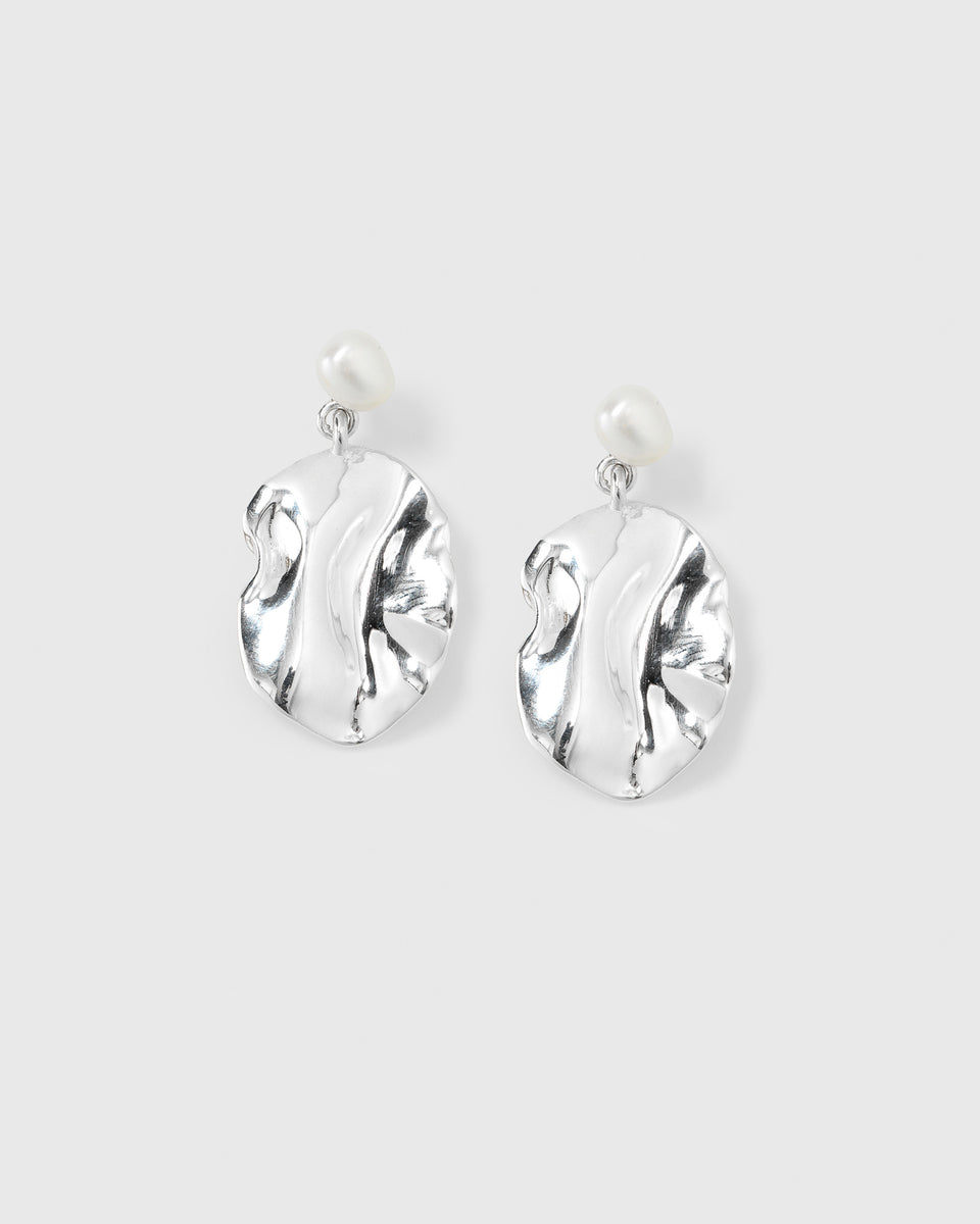 A product shot of the Moulded Short Earrings in silver, featuring an organic, irregularly shaped pendant dangling from a white freshwater pearl stud.