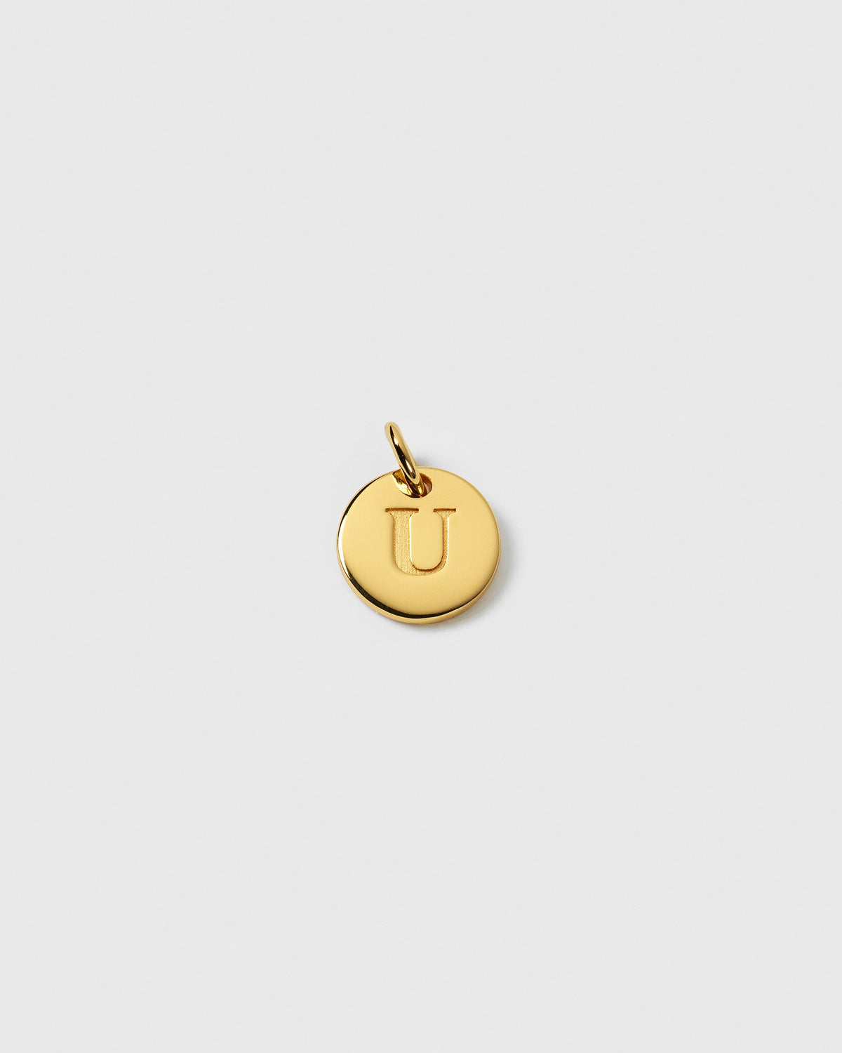 A product shot of the Beloved Mini Letter Gold charm, showing the round gold pendant with the letter 'U' engraved in the center.
