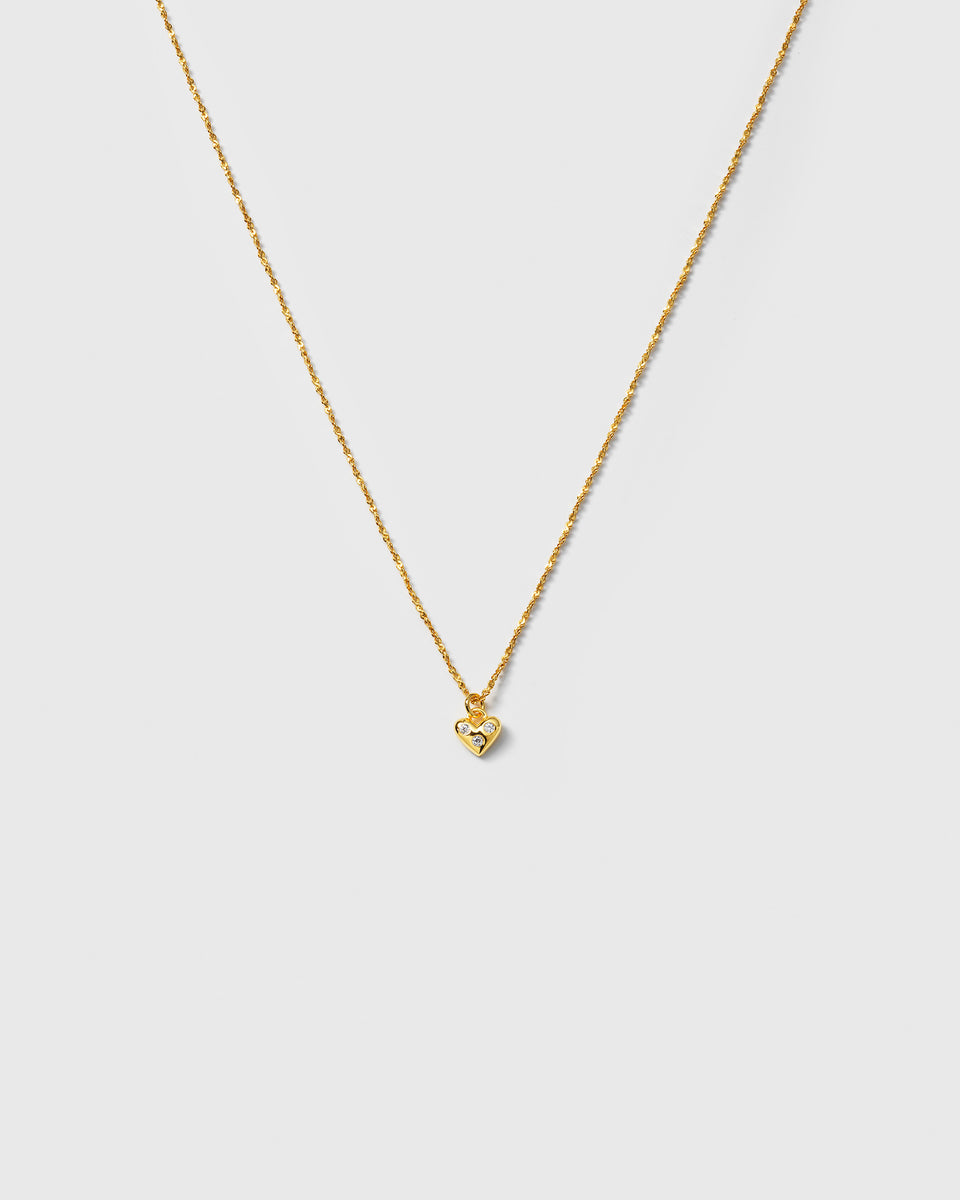 A product shot of the Forever Necklace in gold, featuring a unique twisted chain and a delicate heart pendant adorned with sparkling cubic zirconia stones.