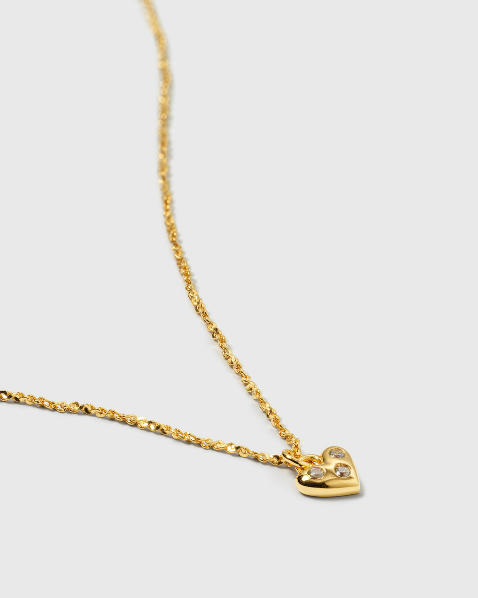 A product shot of the Forever Necklace in gold, highlighting its twisted chain and delicate heart pendant adorned with sparkling cubic zirconia stones.