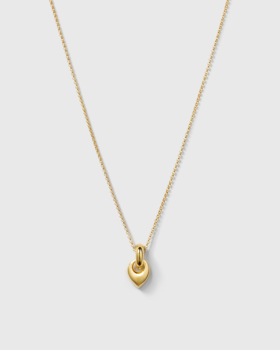A product shot of the Melinda Long Necklace in gold, showcasing its long rolo chain and chunky, nature-inspired leaf-shaped pendant.