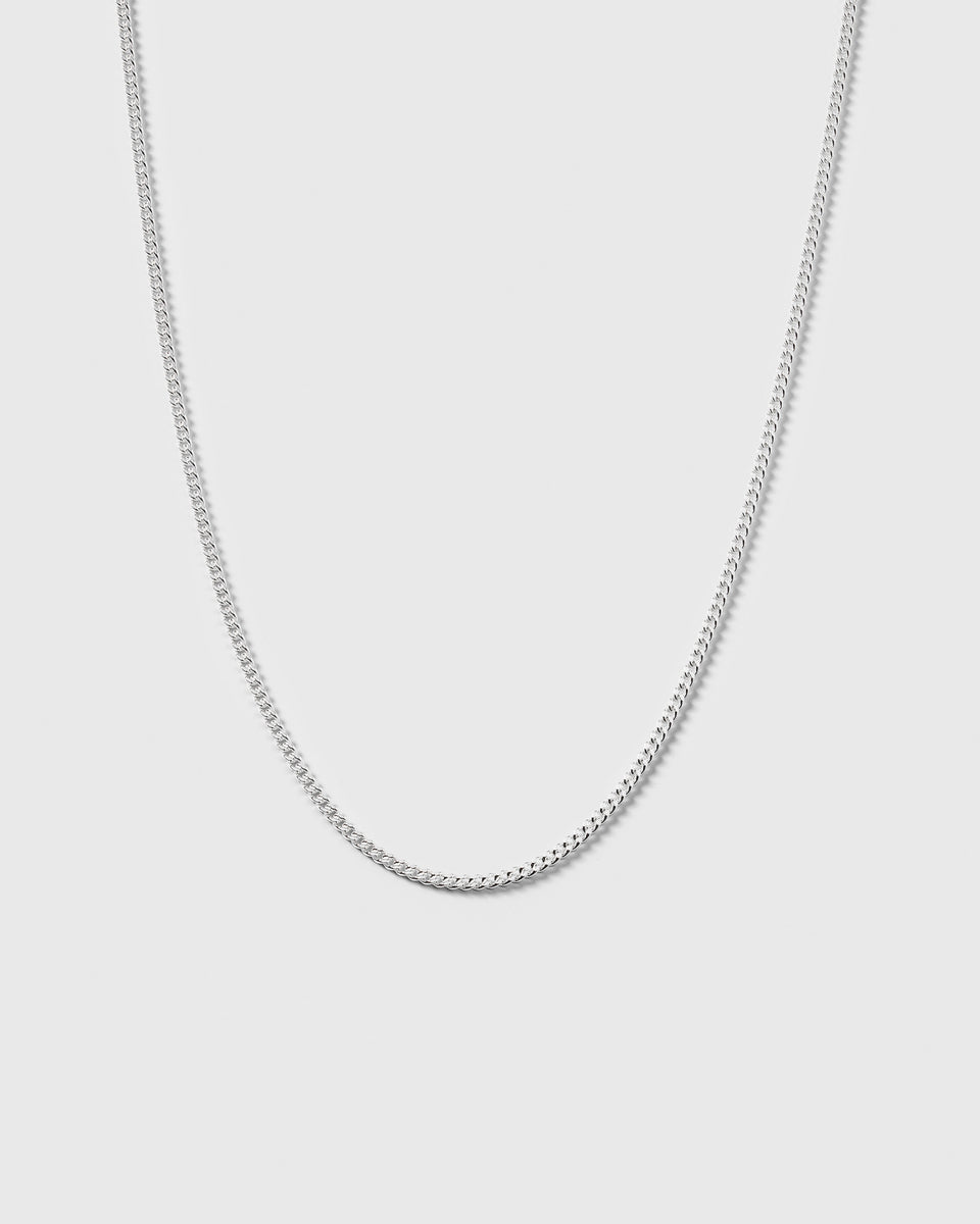 A product shot of the Beloved Short Curb Chain in silver, hanging in a gentle curve to display its classic link design.