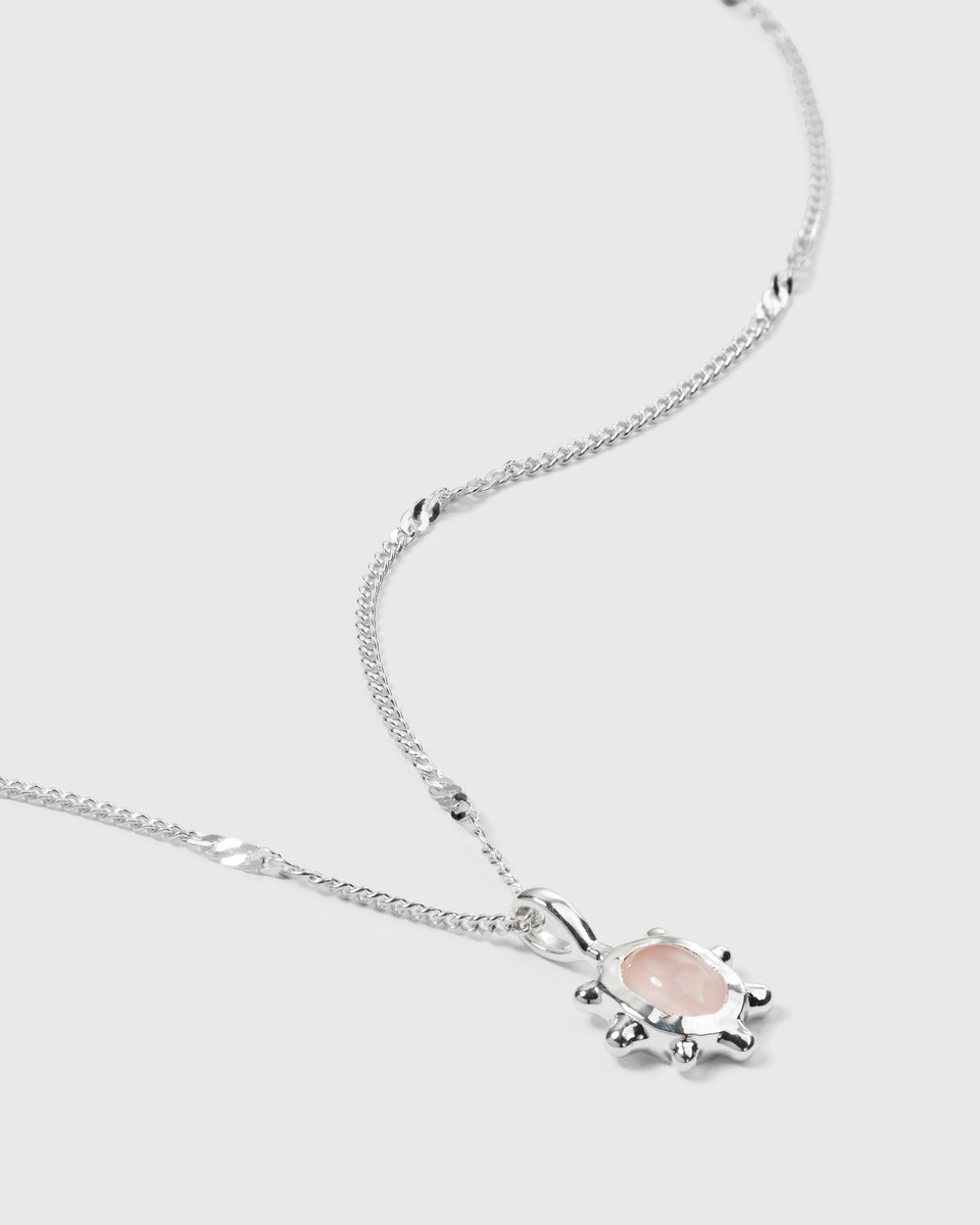 A product shot of the Florentina Necklace in silver, showcasing its delicate twisted chain and flower-shaped pendant set with a rose quartz stone.