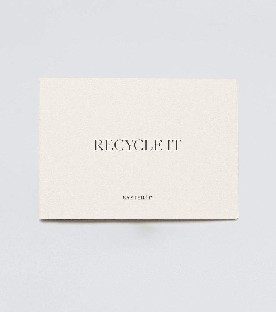 A product shot of the cream-colored Syster P 'Recycle It' card, representing the coupon to recycle a silver chain.