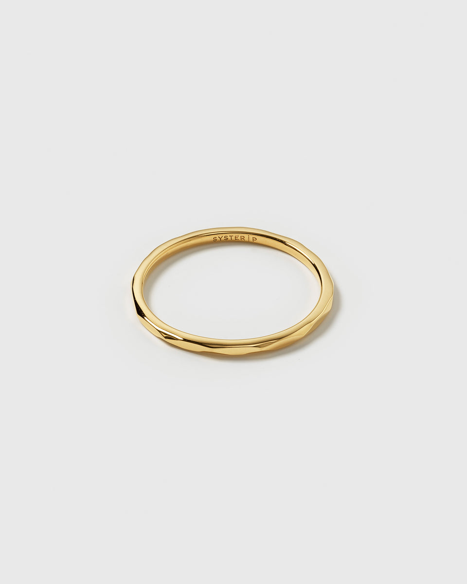 A product shot of the Tiny Ultrathin Ring in gold, highlighting its thin band and slightly structured design.