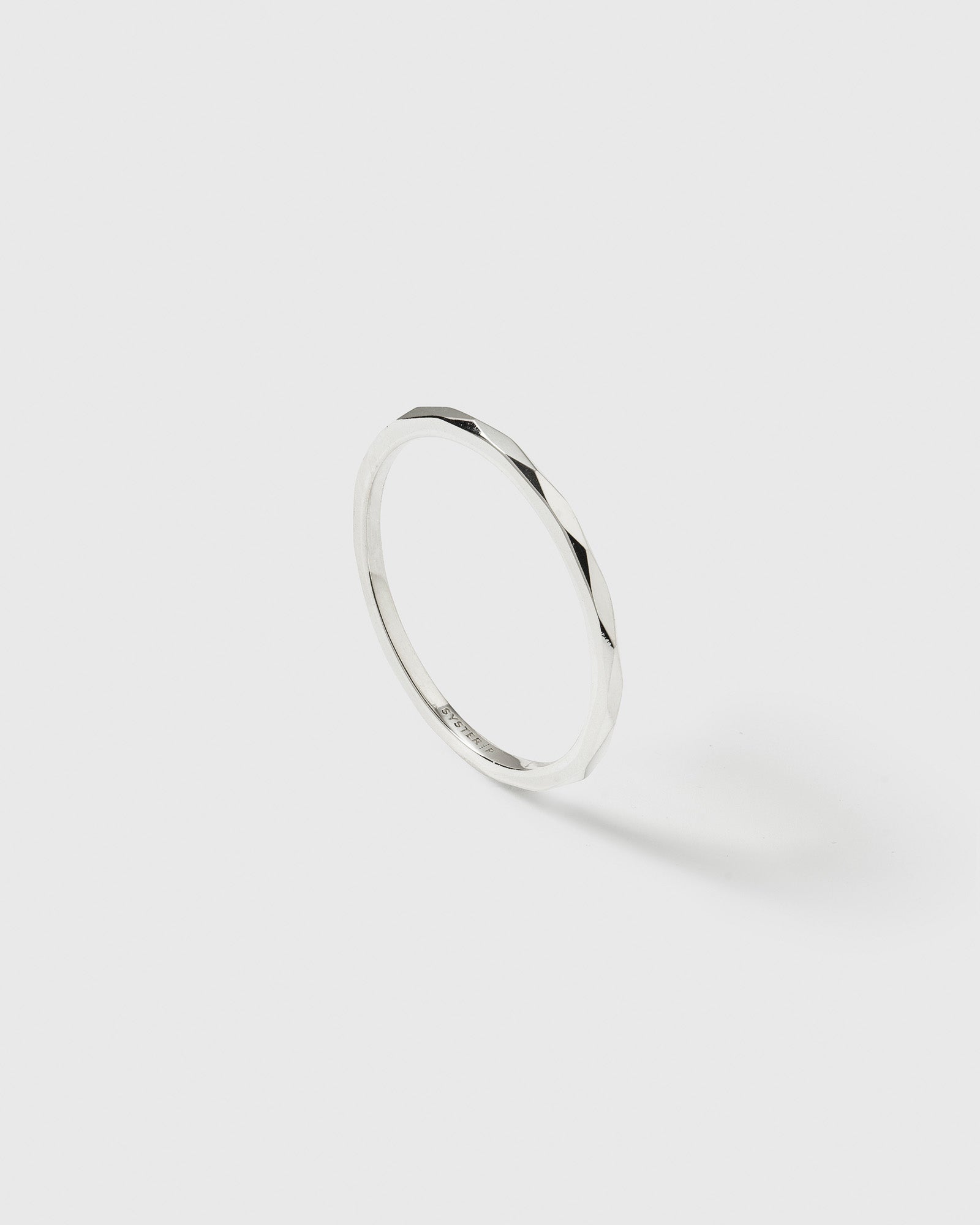 A product shot of the Tiny Ultrathin Ring in silver, highlighting its delicate band and faceted surface.
