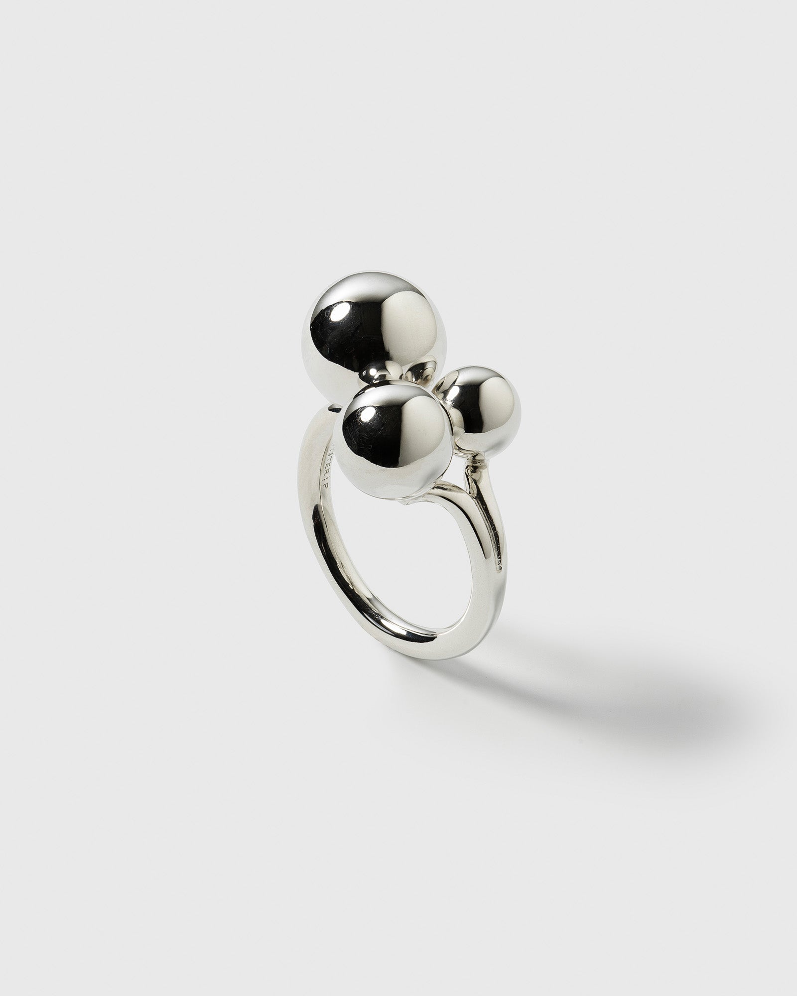 A product shot of the Universe Ring Silver, showcasing its bold design with three polished spheres of varying sizes on a simple band.